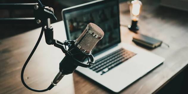 A recording microphone beside a laptop